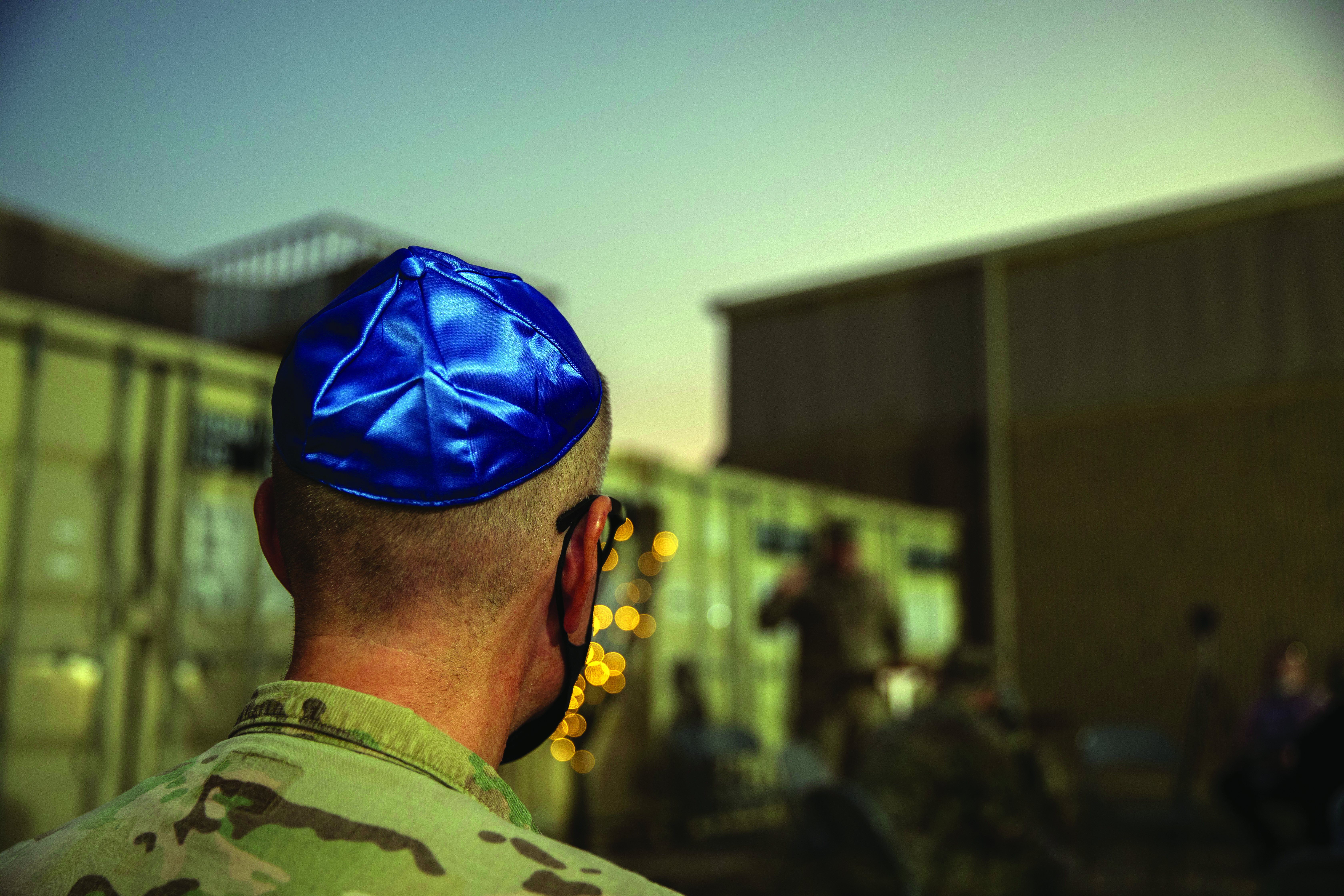 A Service member wears religious headgear during a menorah lighting ceremony in December 2020 on Camp Arifjan, Kuwait. The ceremony was made available
        for all Service members in recognition of the Jewish holiday Hanukkah. (Credit: SGT Khylee Woodford)